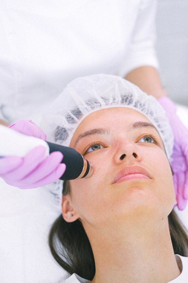 Mujer recibiendo un tratamiento facial con tecnología láser en una clínica estética
